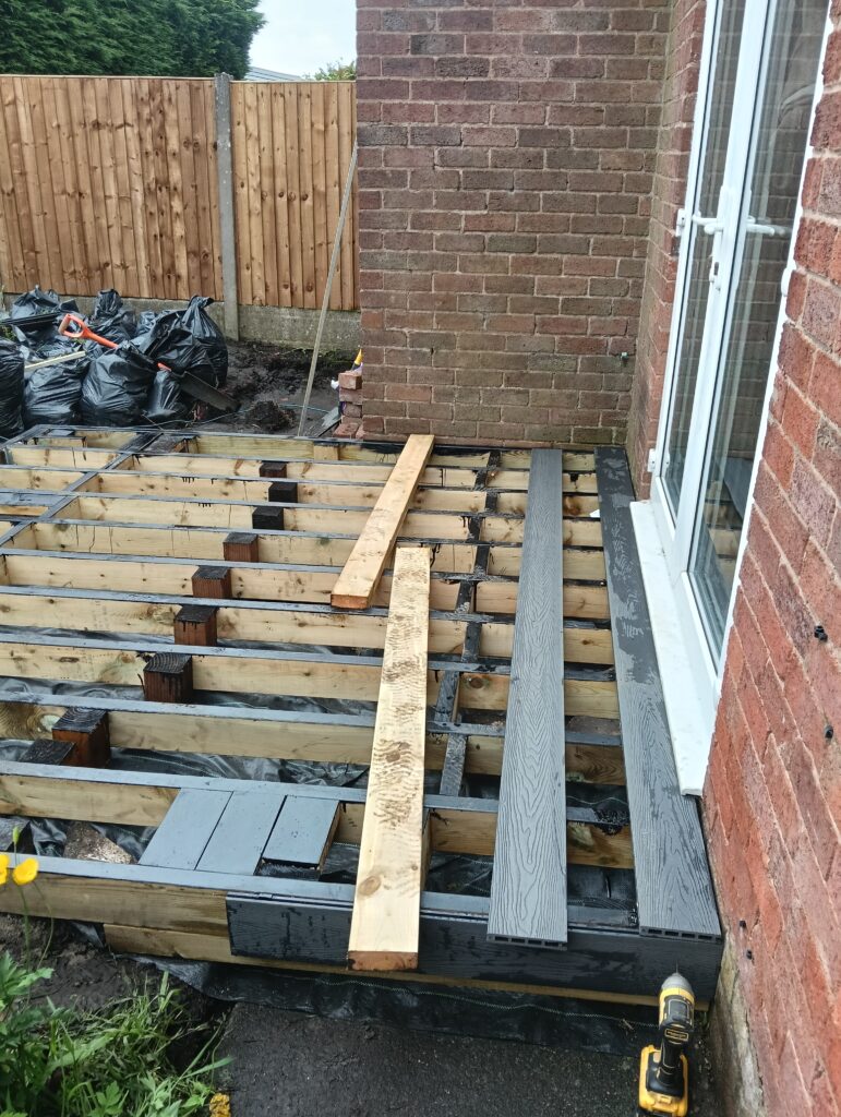 First grey composite decking boards being fitted in Bolton
